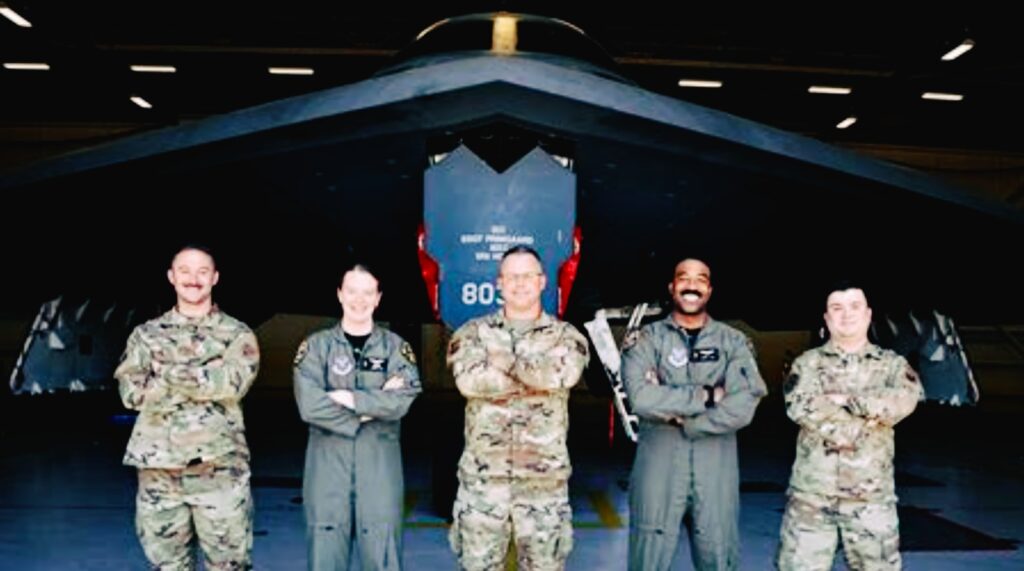 B-2 Spirit flight crew and support personnel standing in front of aircraft in hangar at Whiteman AFB